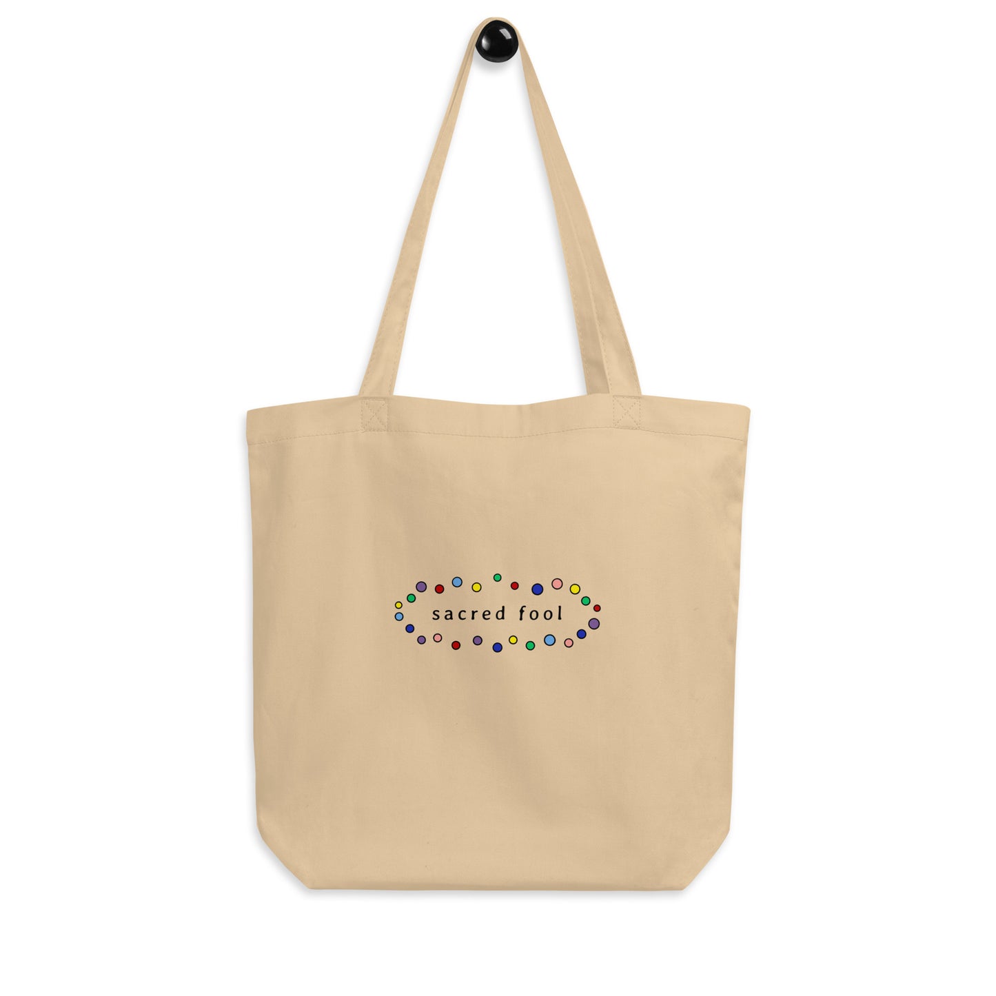 back of natural oyster colored organic cotton tote bag with black sacred fool logo surrounded by small bubbles of color.