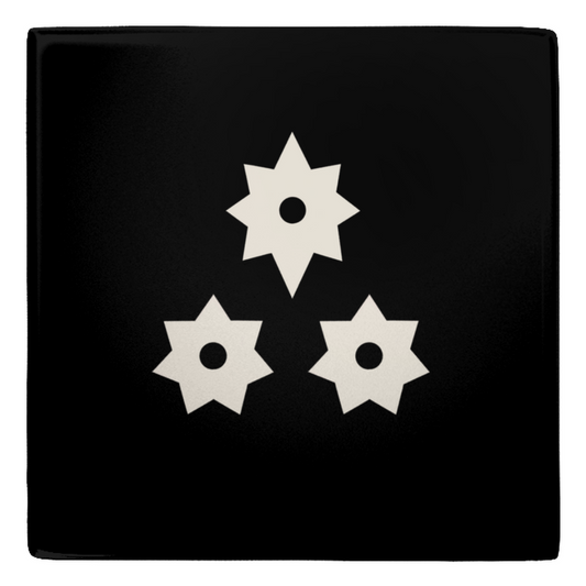 a square magnet with a white trio of stars centered against a black background.