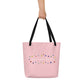 pale pink tote bag with black cotton handles featuring a white logo that reads 'sacred fool' surrounded by an irregular ring of colorful polka dots centered on back of bag.