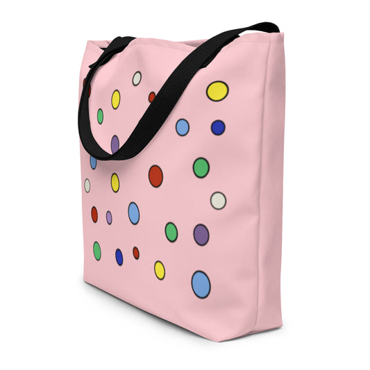 a large multicolored polka dotted tote bag in a soft pink with black cotton handles.