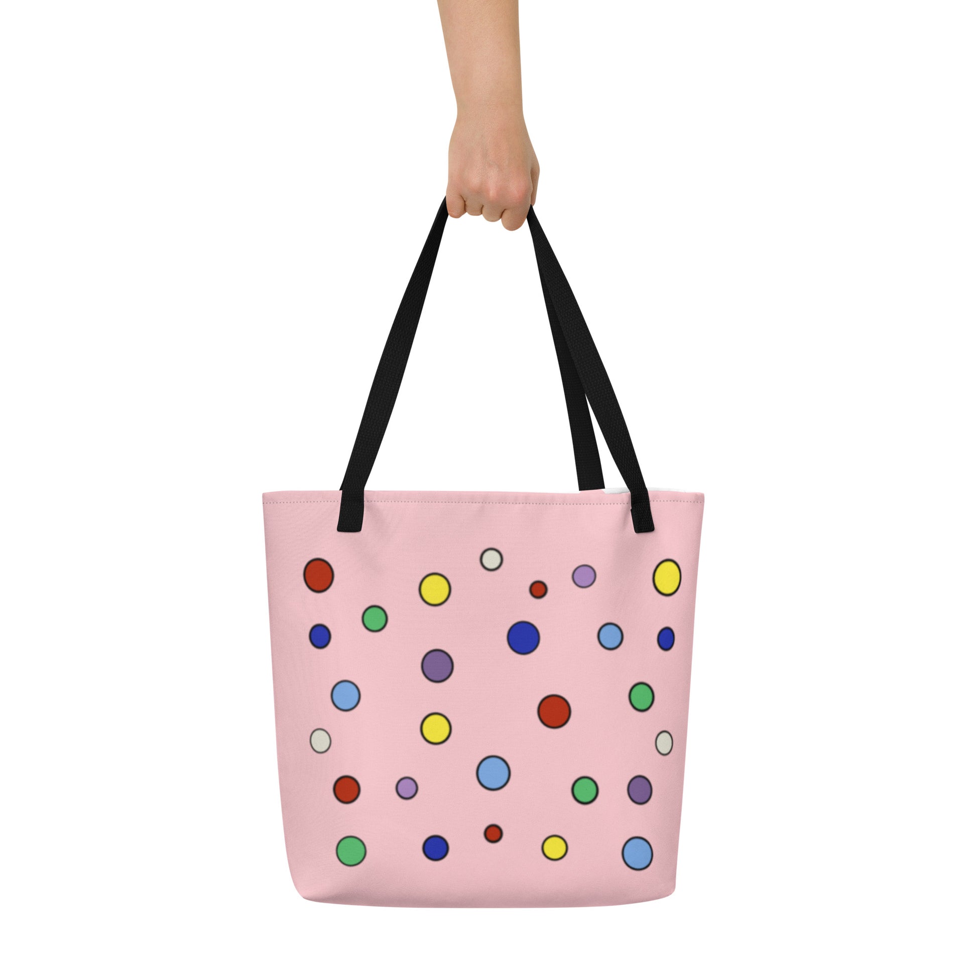 front view of pale pink shopping tote decorated in multicolored polka dots radiating from a ring of five in the center resembling atomic particles.