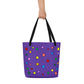 full frontal view of bold purple tote bag with rainbow polka dot design being held by its black straps. 