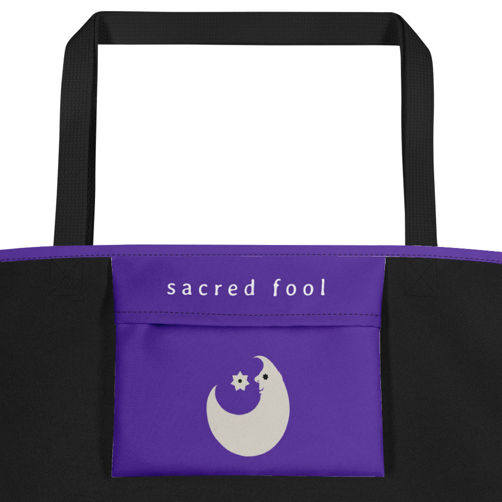 the interior enclosed pocket of the wizard tote is adorned with a white smiling crescent moon with a black star as his eye and a seven pointed white star with black spot at its center hovering over the moon's stomach and near its nose. above the moon is sacred fool's logo in white.
